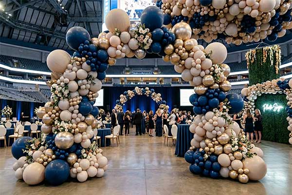 A massive, elegant organic balloon installation framing a stage for a premium corporate event in Fort Worth.