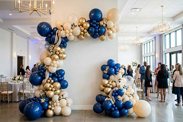 An experienced balloon decor professional precisely engineering a large-scale, colorful corporate event installation.